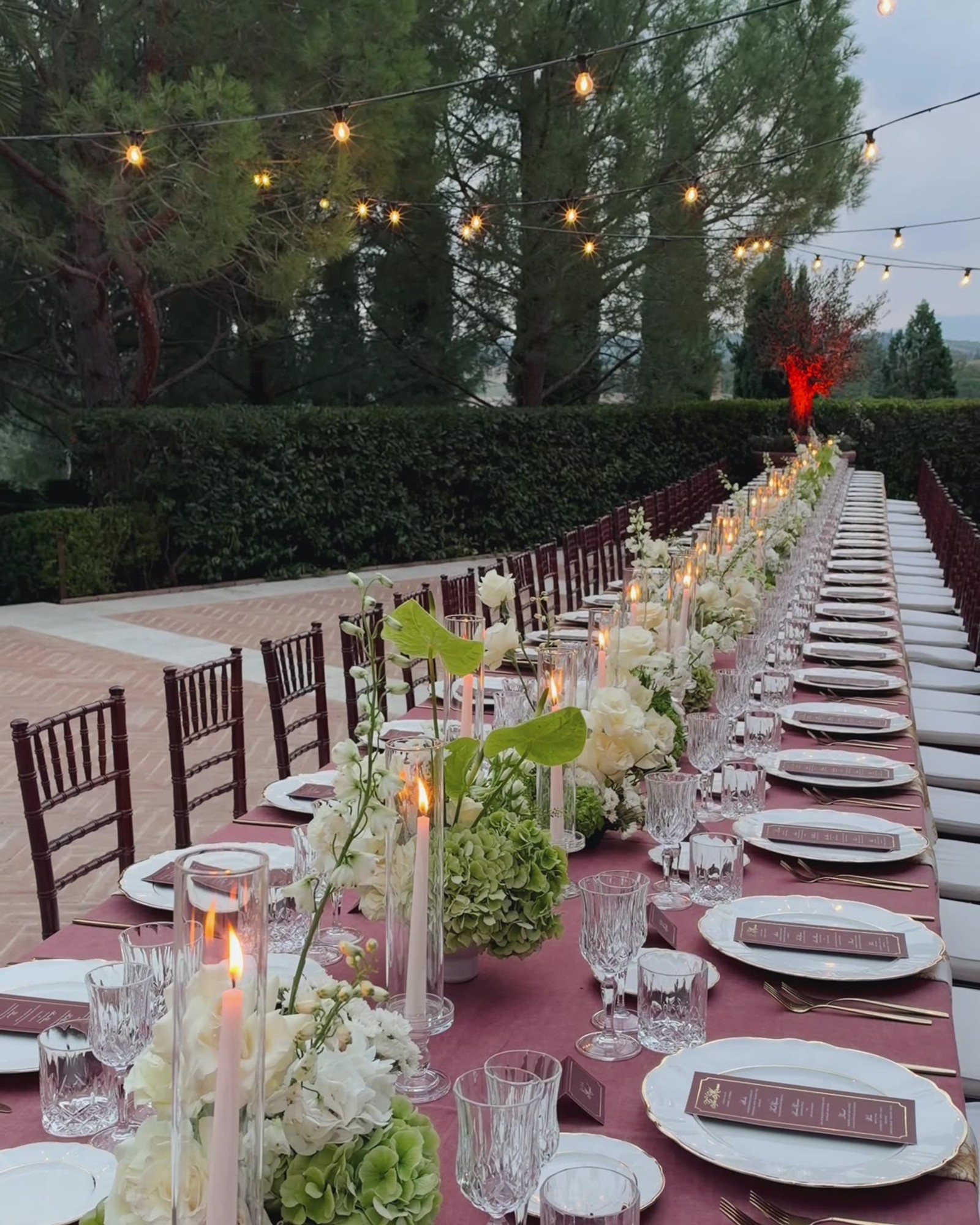 Long candlelit table set for a wedding dinner