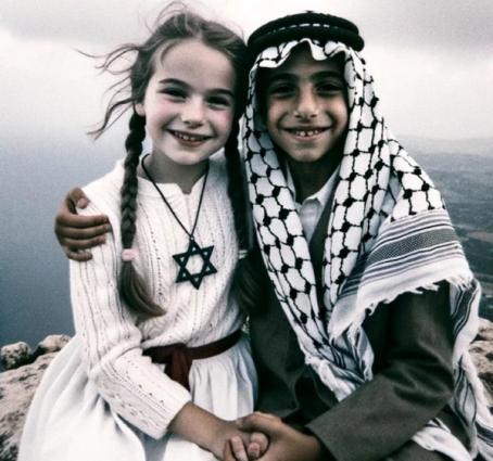 Palestinsk gutt og jødisk jente som holder hender og smiler