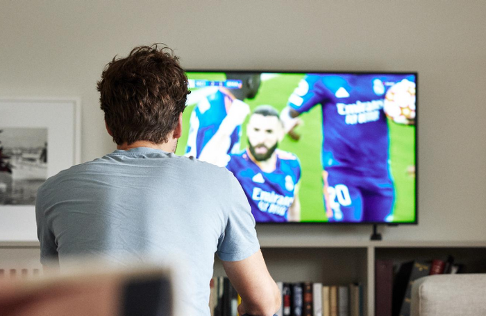 Mann ser fotball på TV 2 Play