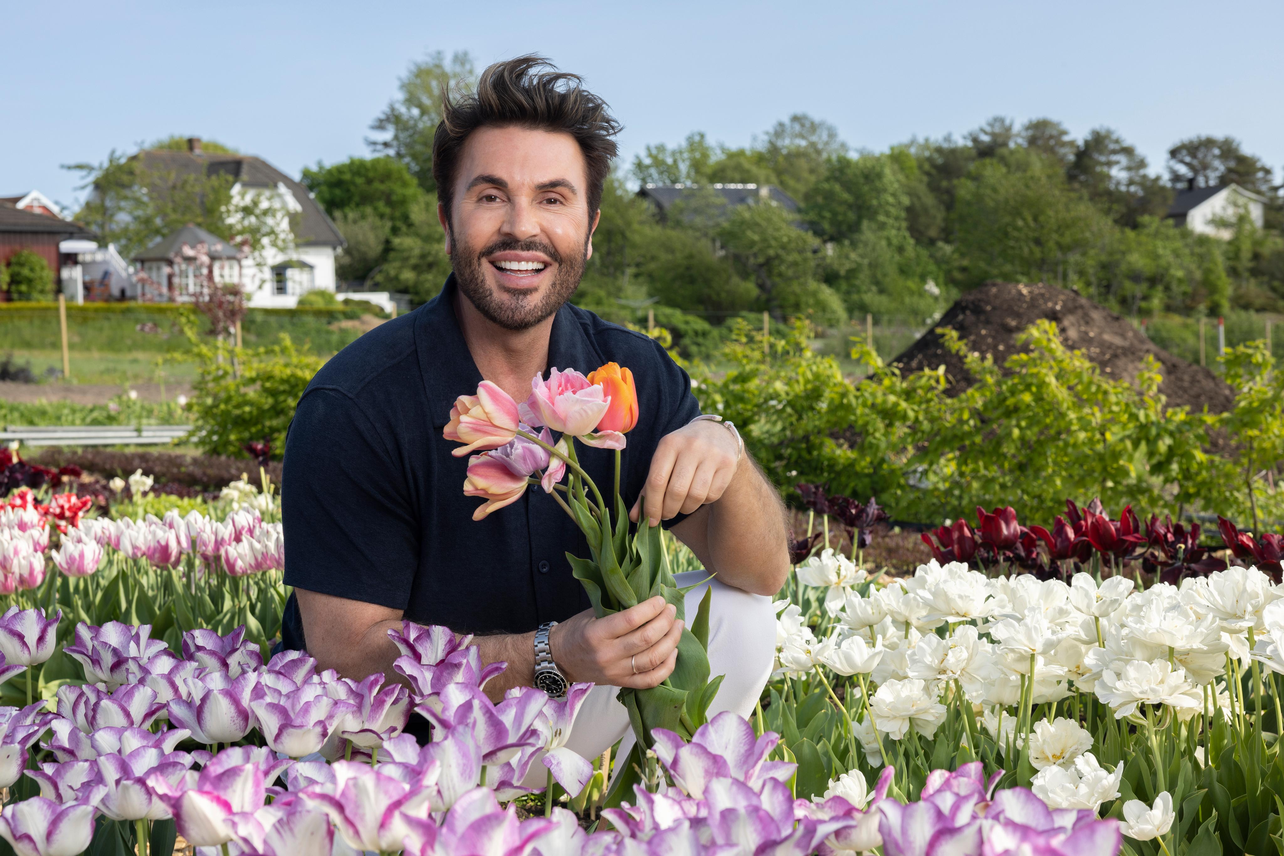 Bilde av programleder Jan Thomas, som sitter i en blomstereng og smiler
