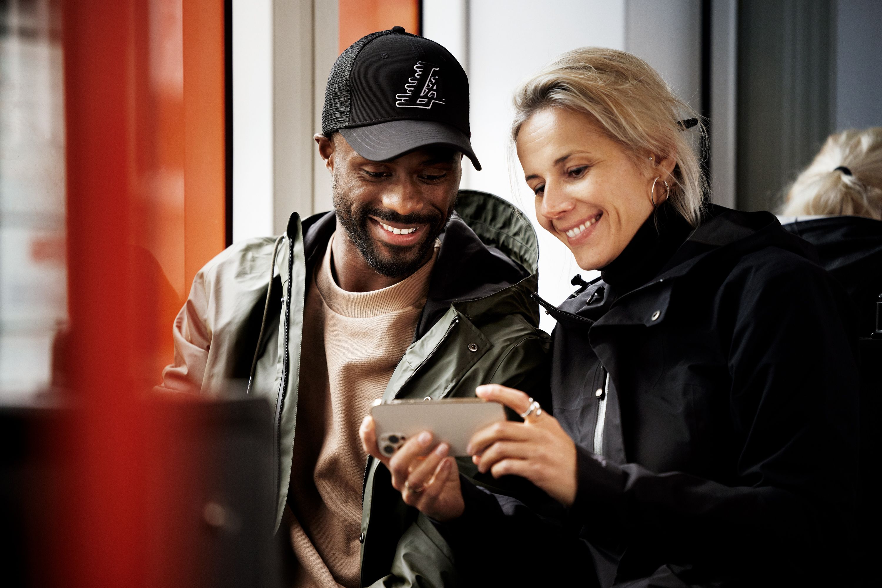 kvinne og mann som ser på Tv 2 Play på mobilen sin