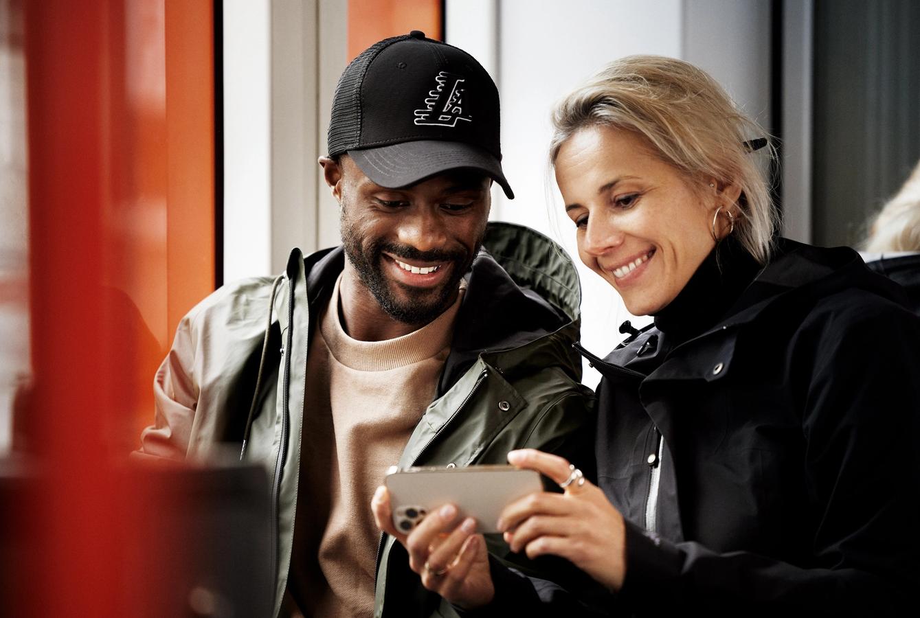 kvinne og mann som ser på Tv 2 Play på mobilen sin