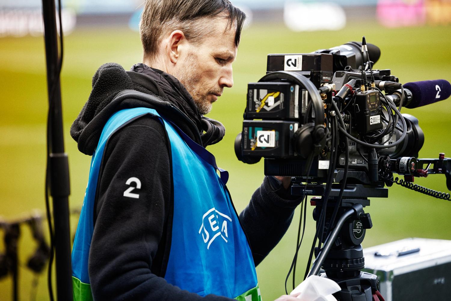 Bilde av TV 2s fotograf med kameraet, på fotballstadion