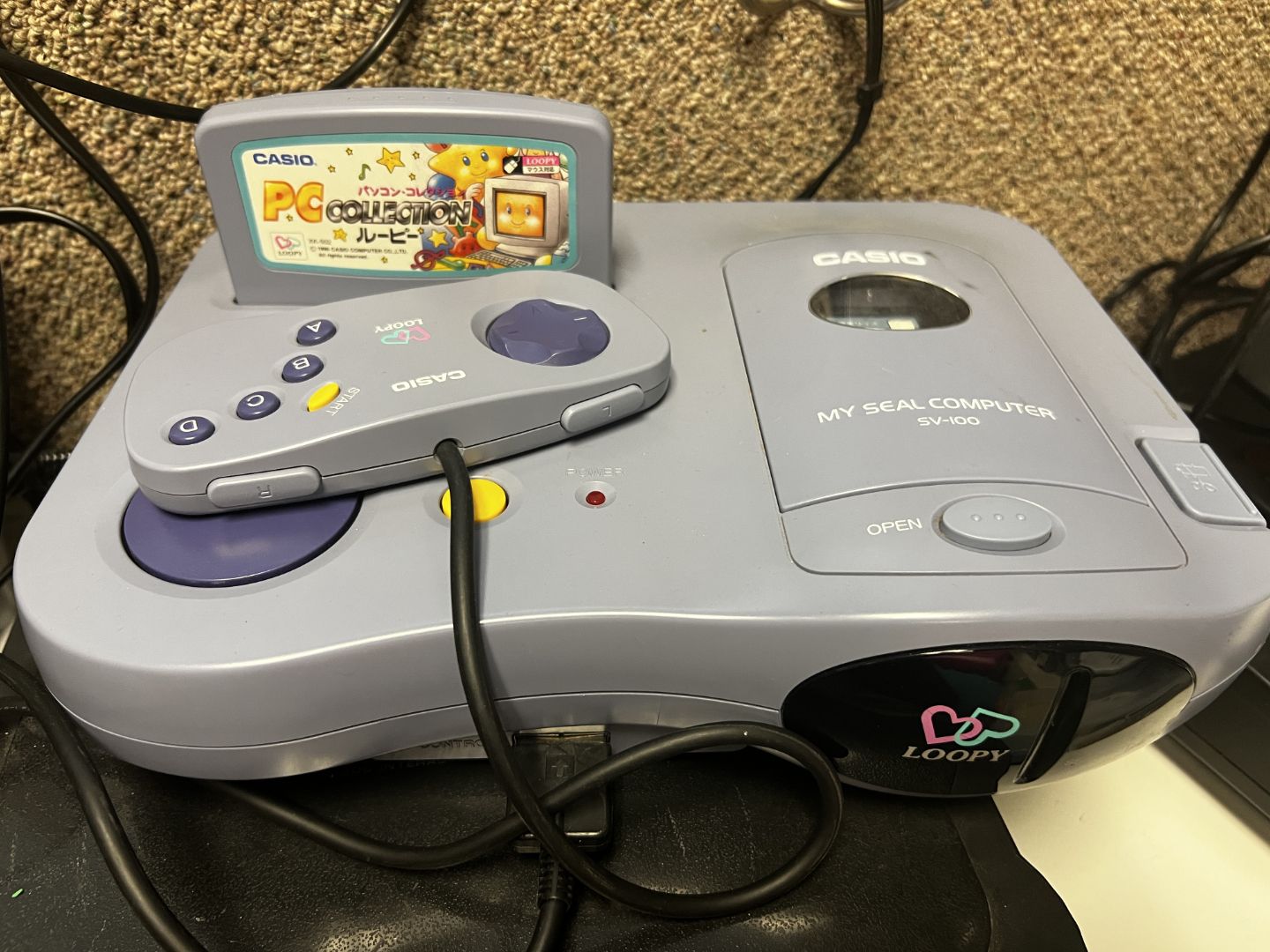 Casio Loopy with controller sitting on top of the console