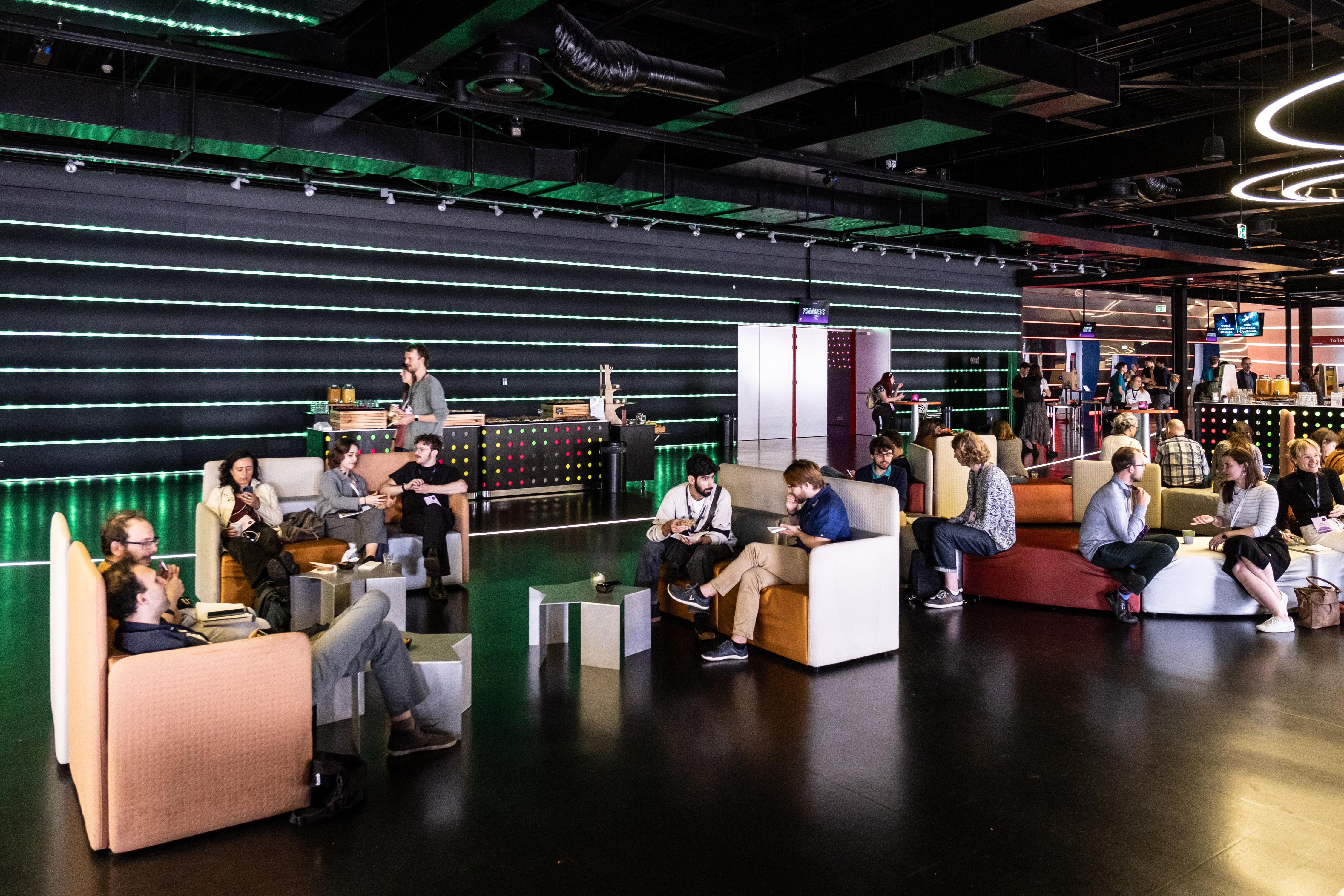 a group of people are sitting on couches in a large room .