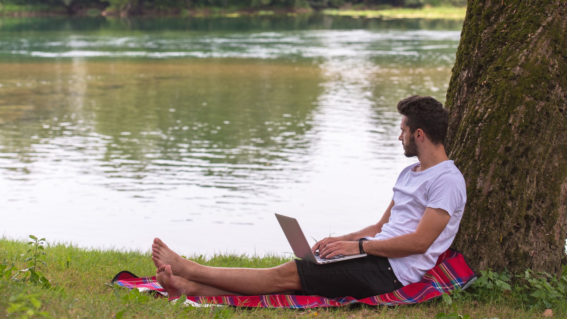 Man with laptop looking away