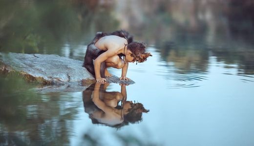 Boy mirrors in water