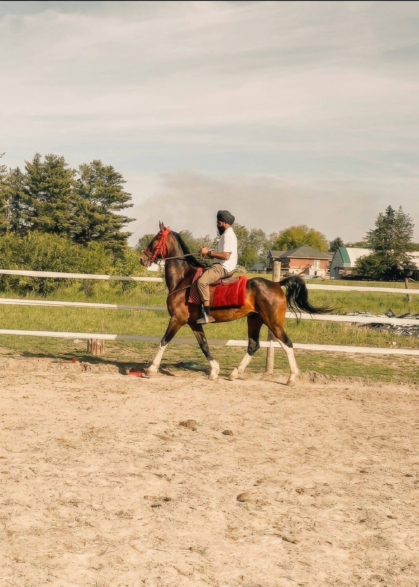 House of Singh founder Maninder Singh riding a horse at an outdoor equestrian arena.
