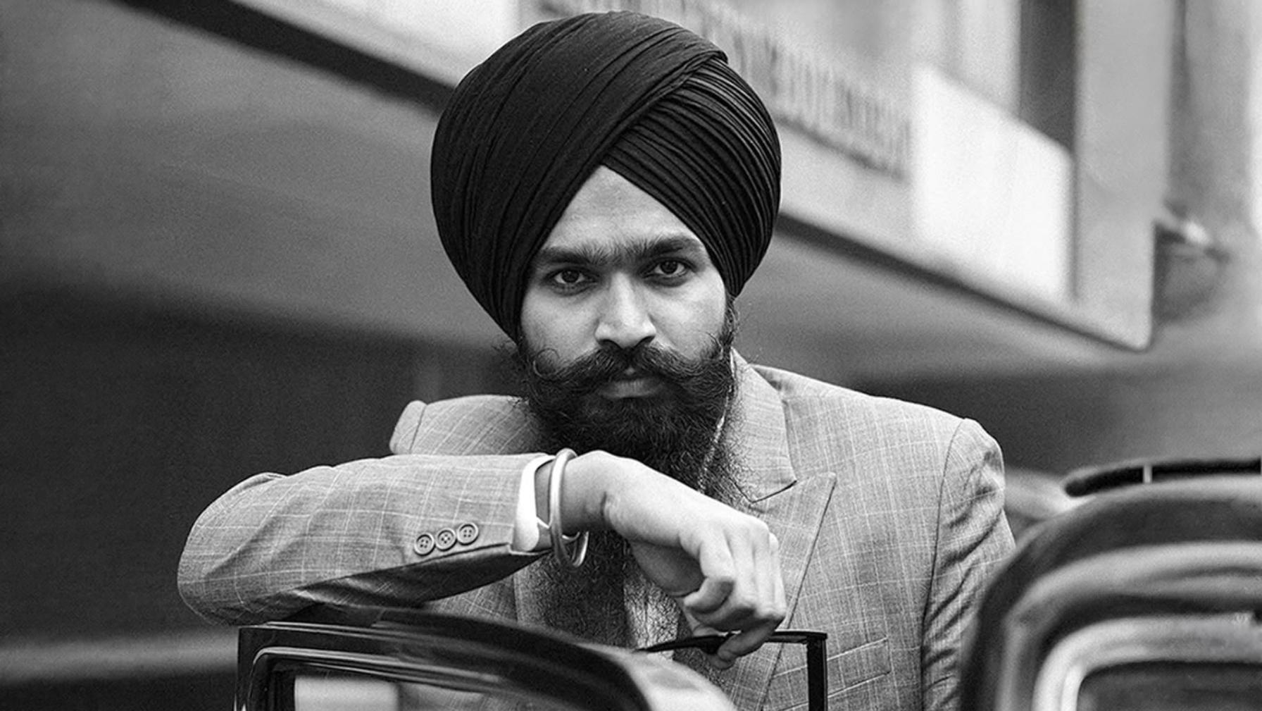 Maninder Singh in a 1950s style double breasted suit and turban, standing with a vintage car at Connaught Place, New Delhi.