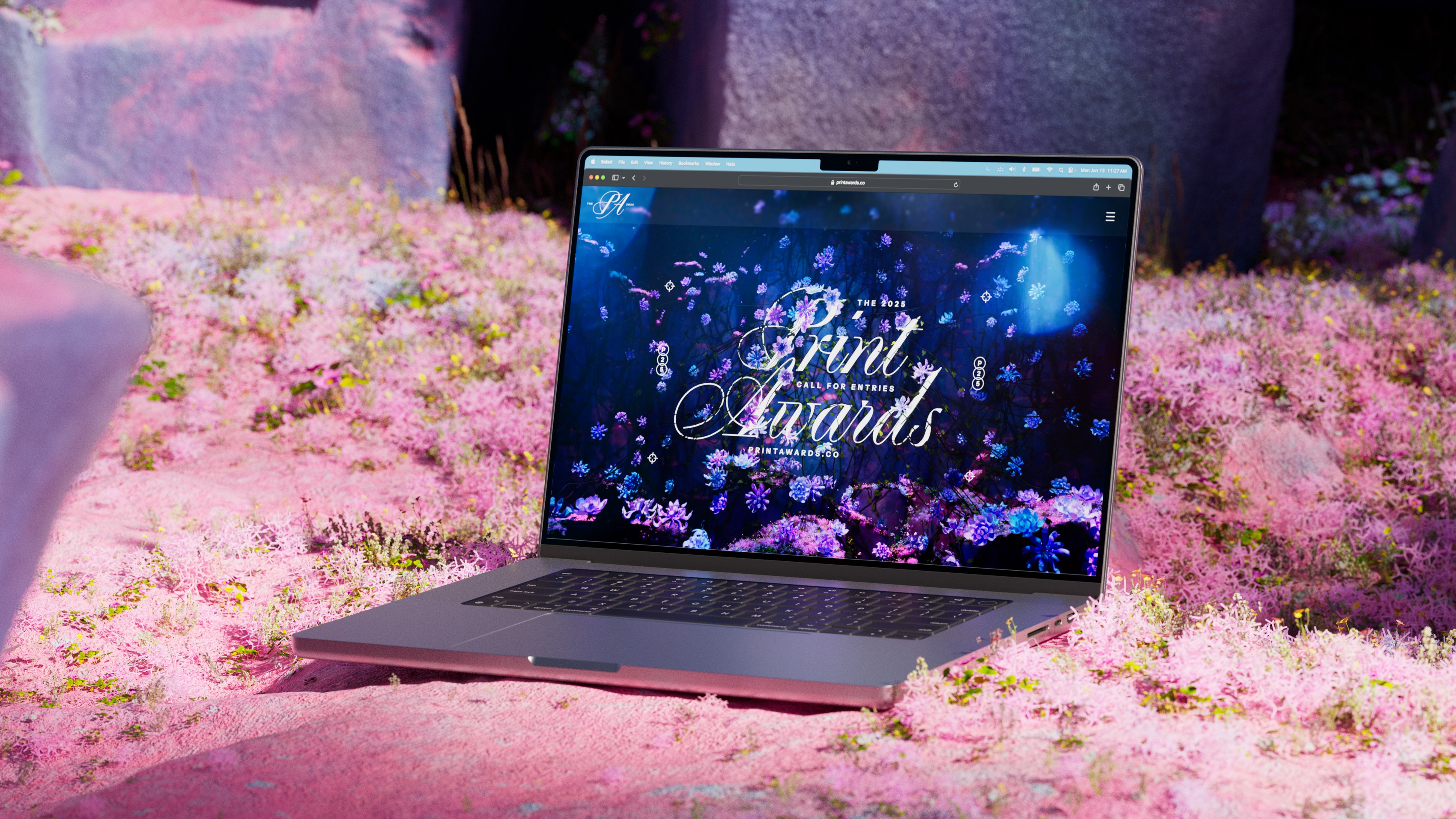 Laptop sitting in lush flora, with Print Awards lockup on screen