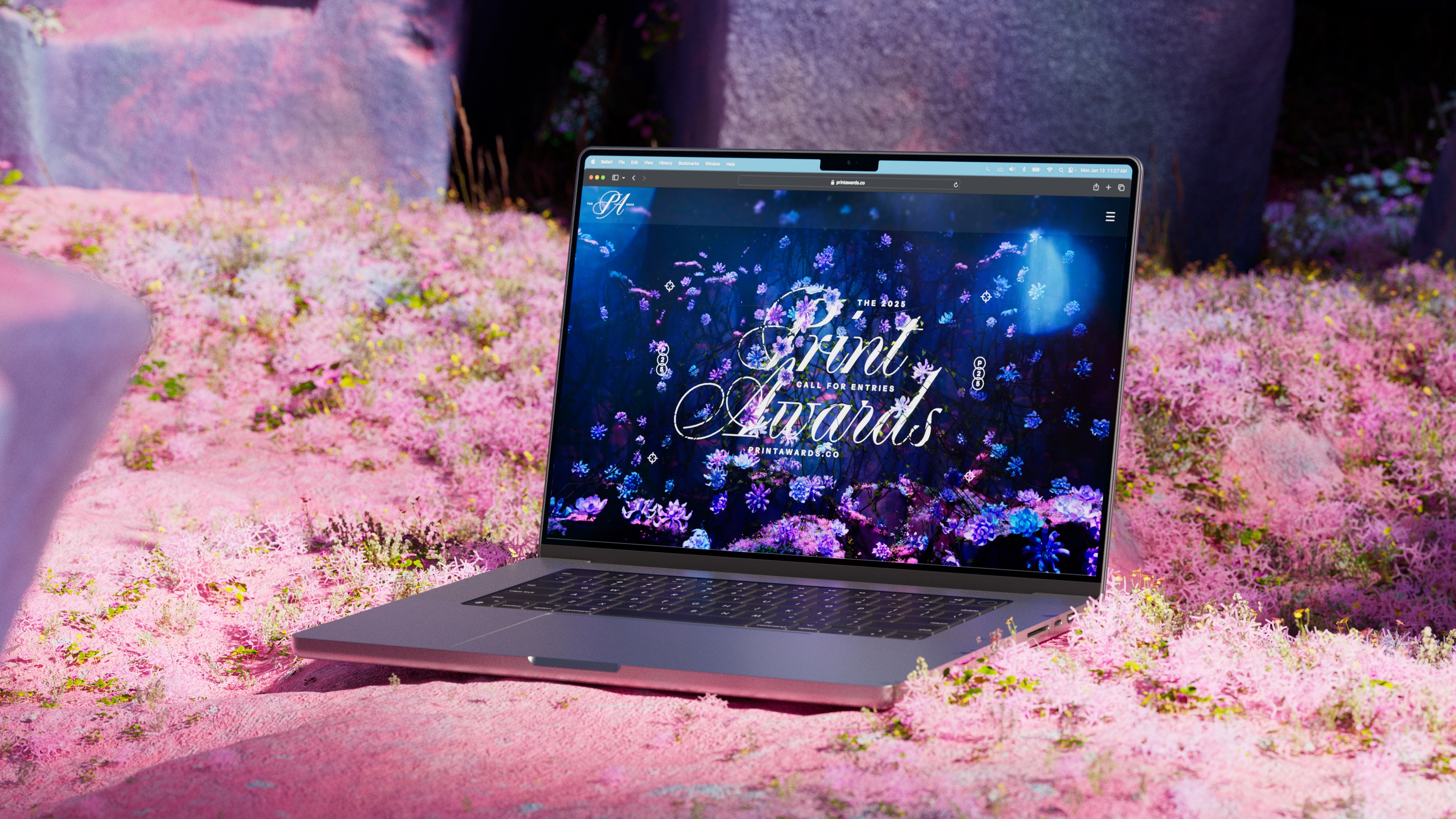 Laptop sitting in lush flora, with Print Awards lockup on screen