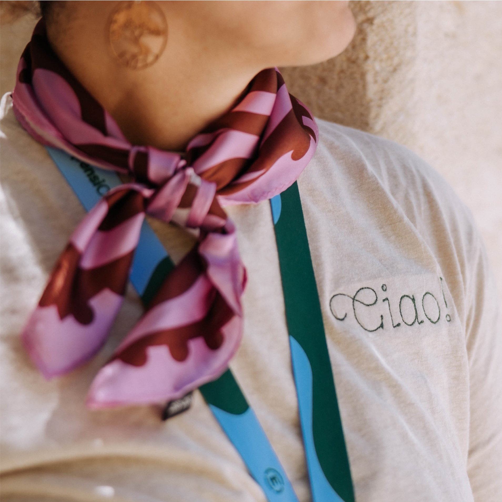 Detail of a silk scarf and t-shirt with the word Ciao on it