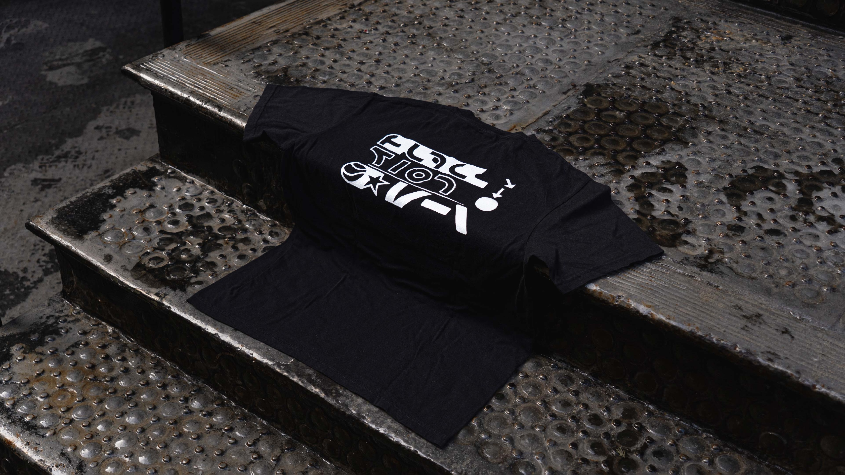 Black graphic tee draped on steps