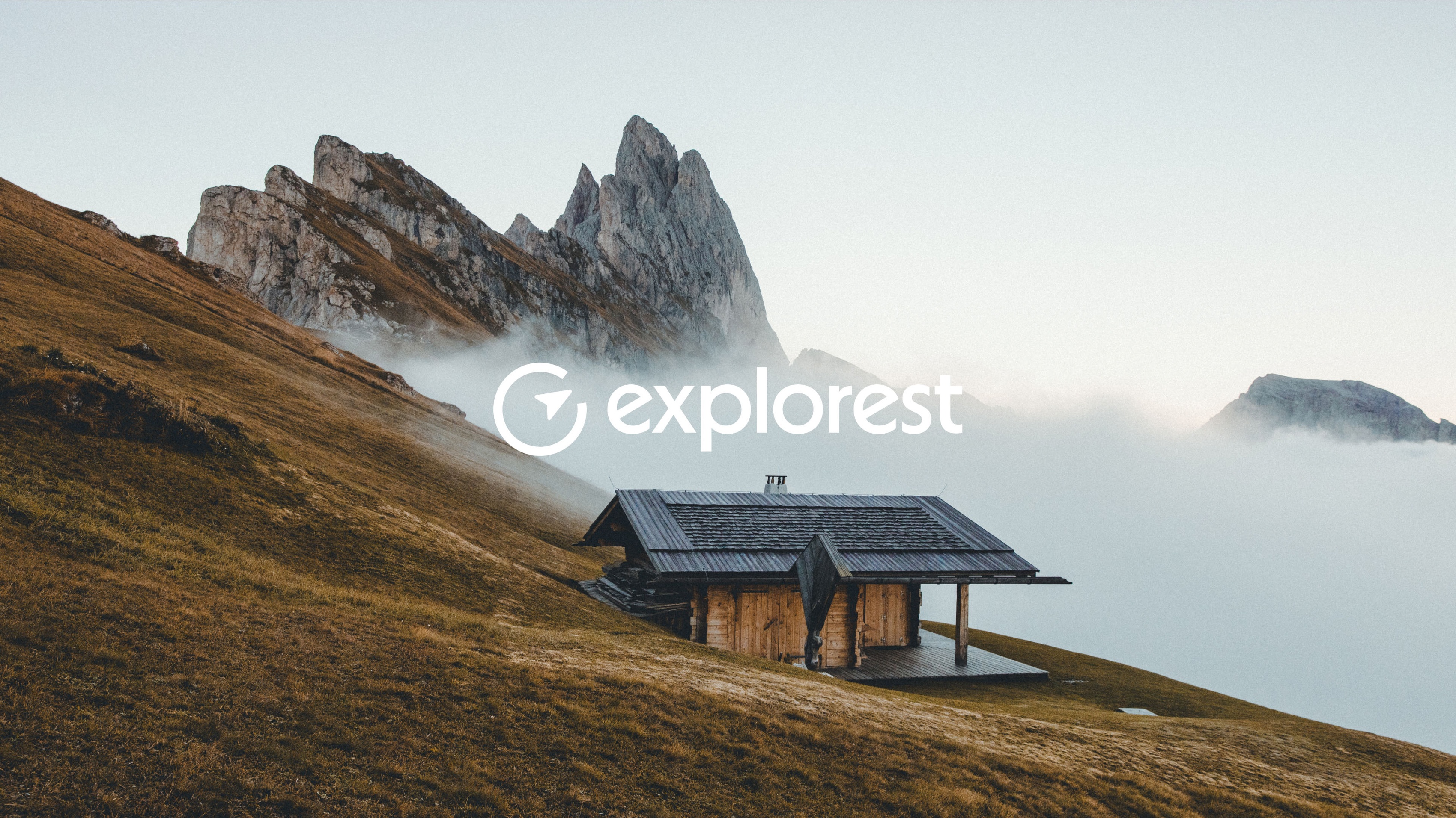 Explorest logo over a photo of a cabin in the fog