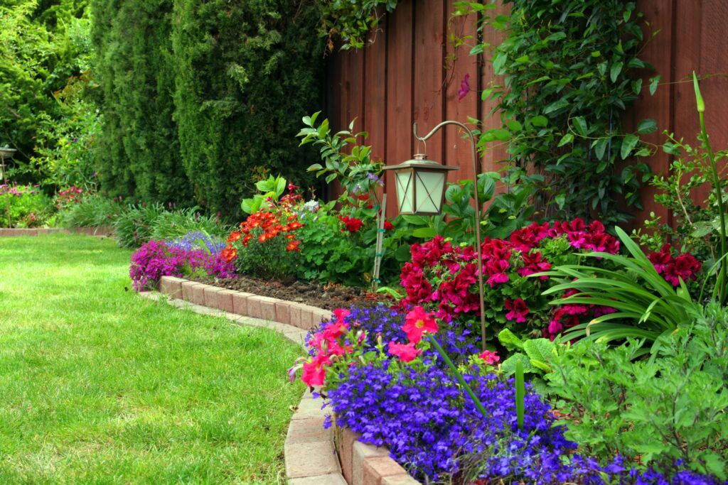 a yard flower bed with brick edging for this colorful garden