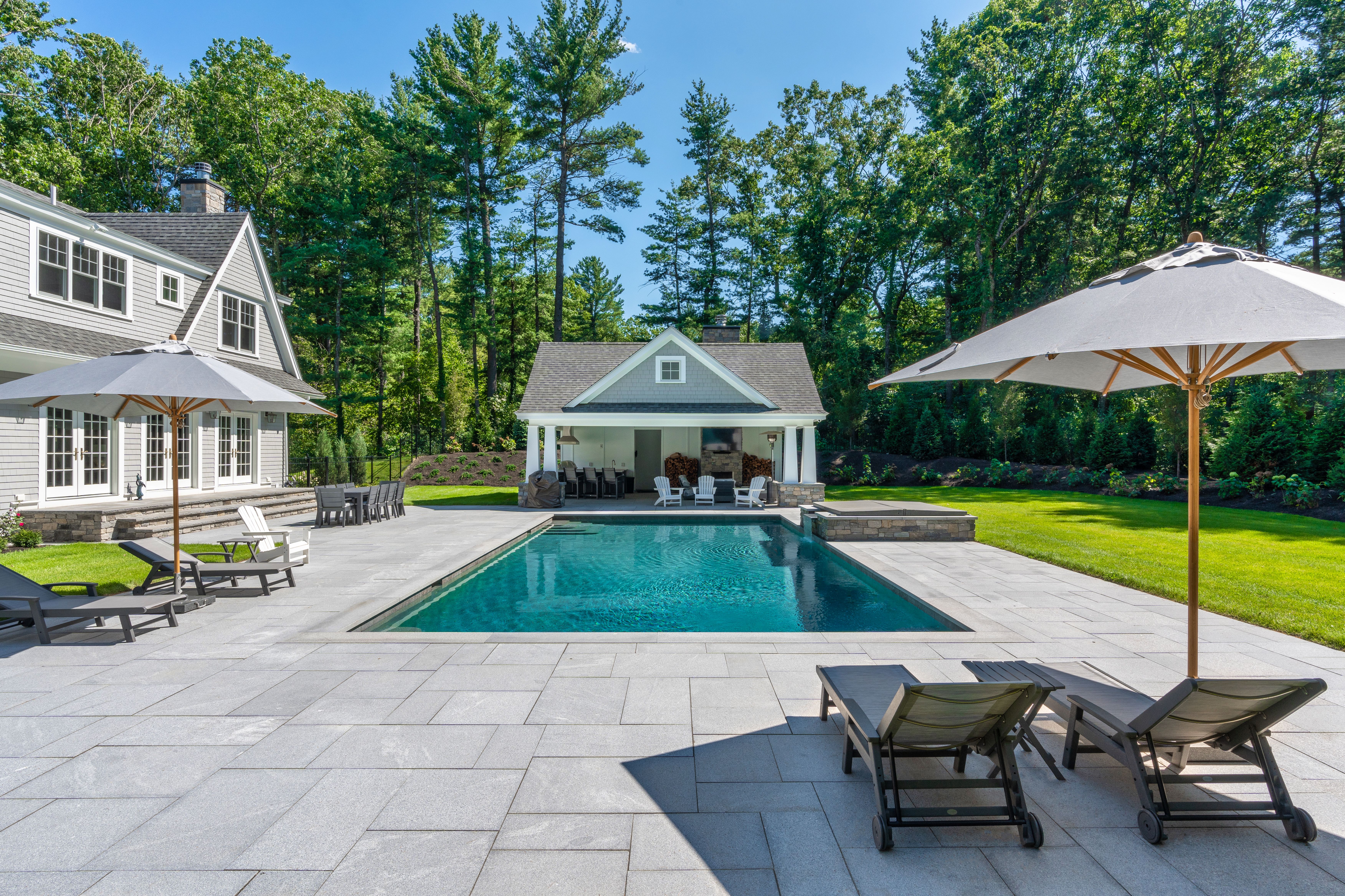 beautiful natural stone pavers in a large backyard around a pool