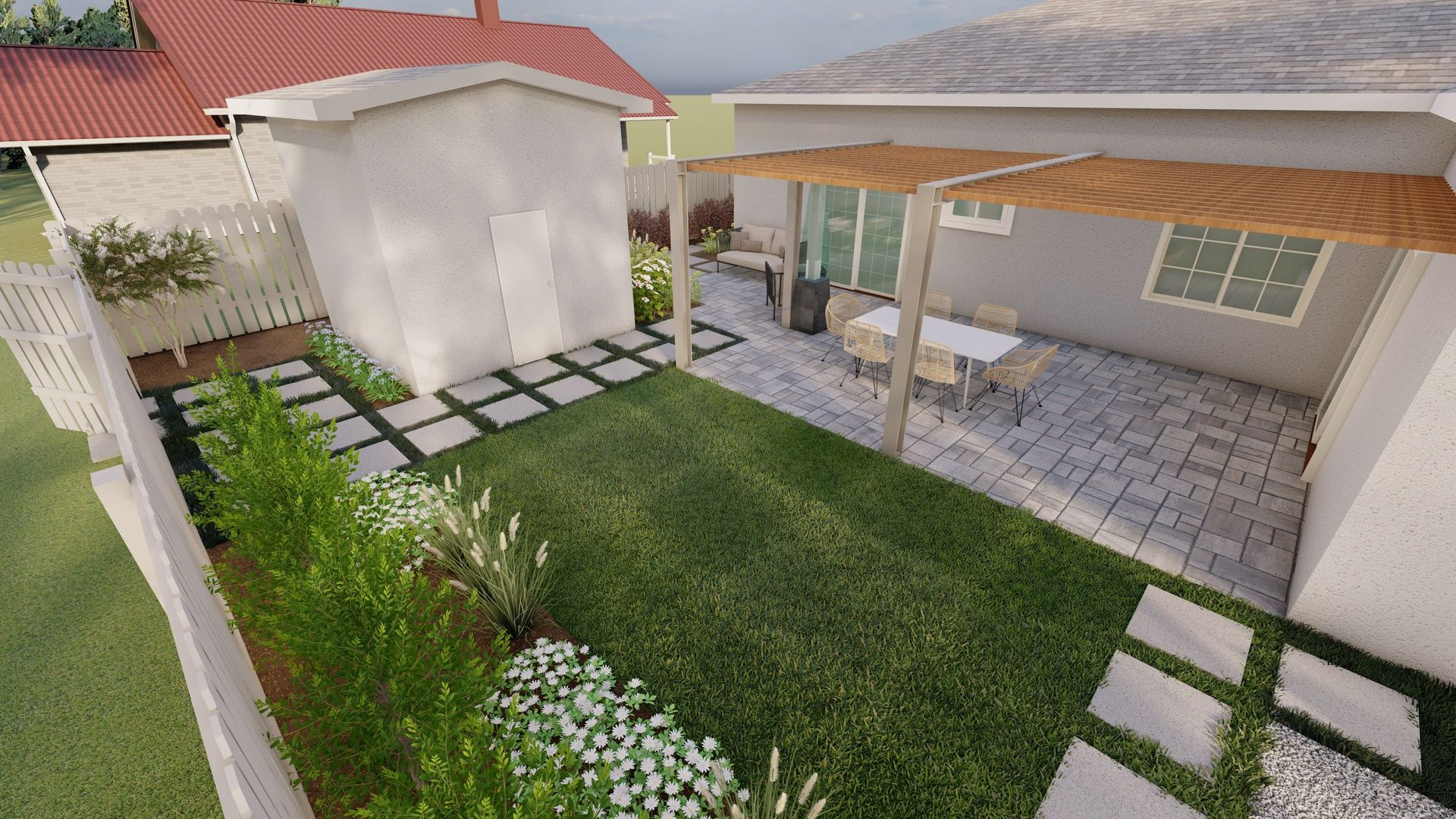 a flagstone patio with grass and pavers and an outdoor shed along a white fence. 