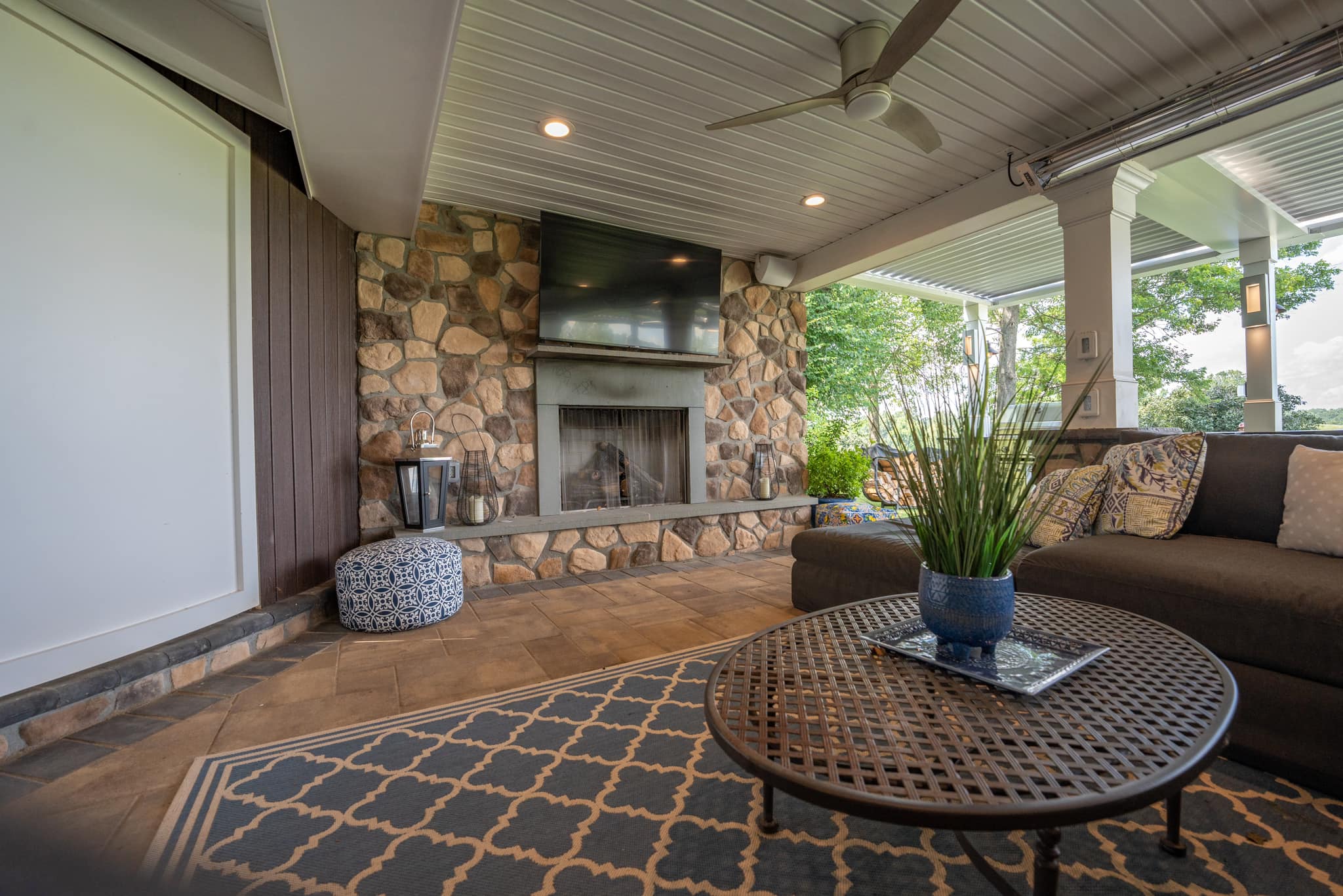 backyard deck ideas an outdoor living room area with a fireplace and TV
