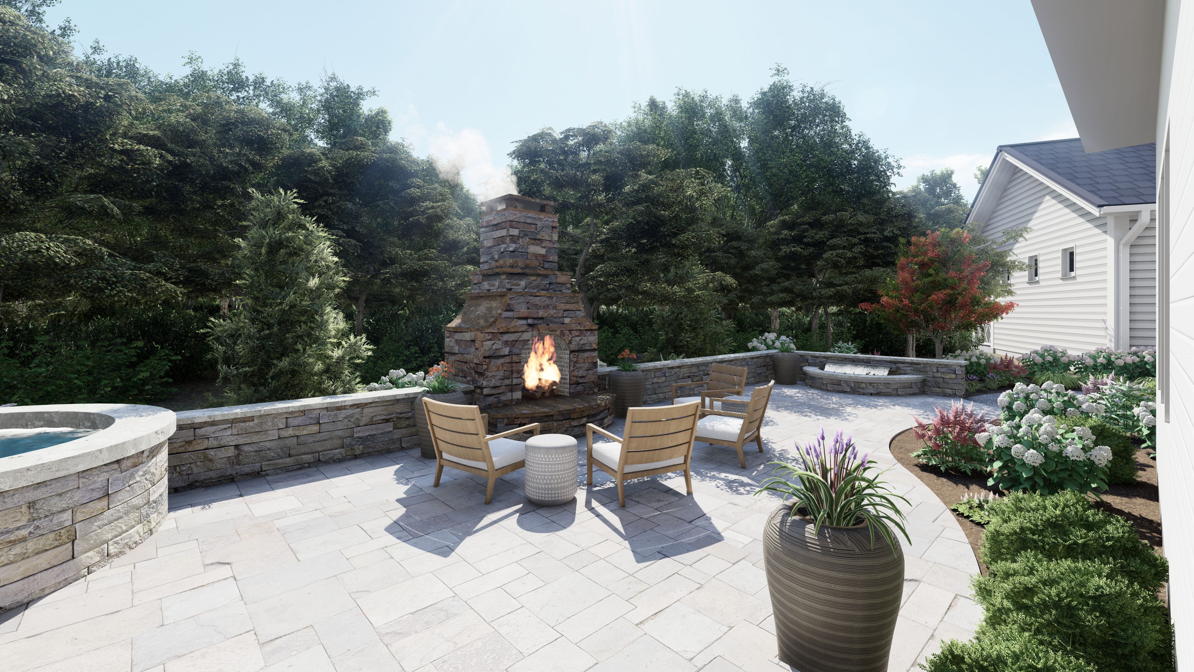 a stone patio in a backyard with an outdoor fire place and outdoor hot tub nestled among colorful flower beds and tall evergreens