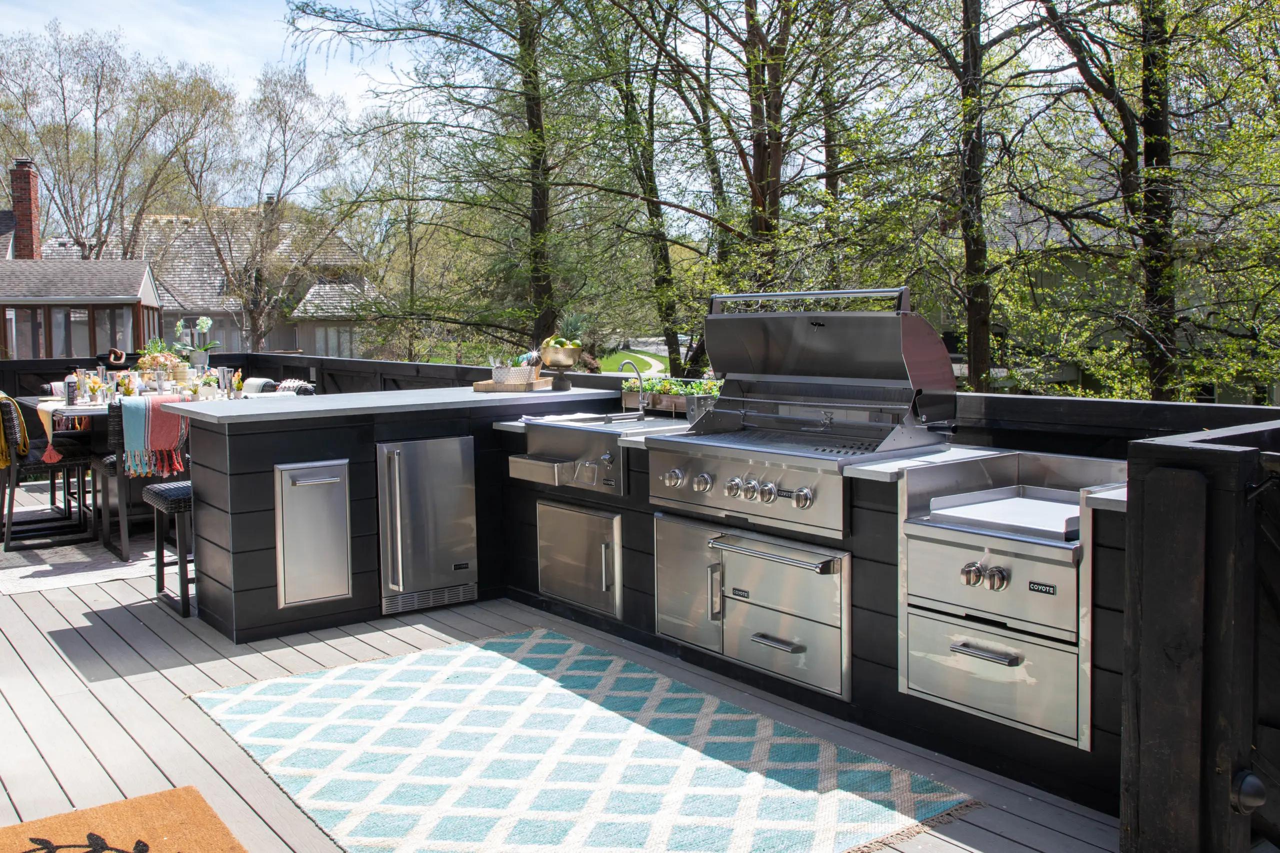 outdoor kitchen ideas with a family grill and sink near a table by the back wall of the house