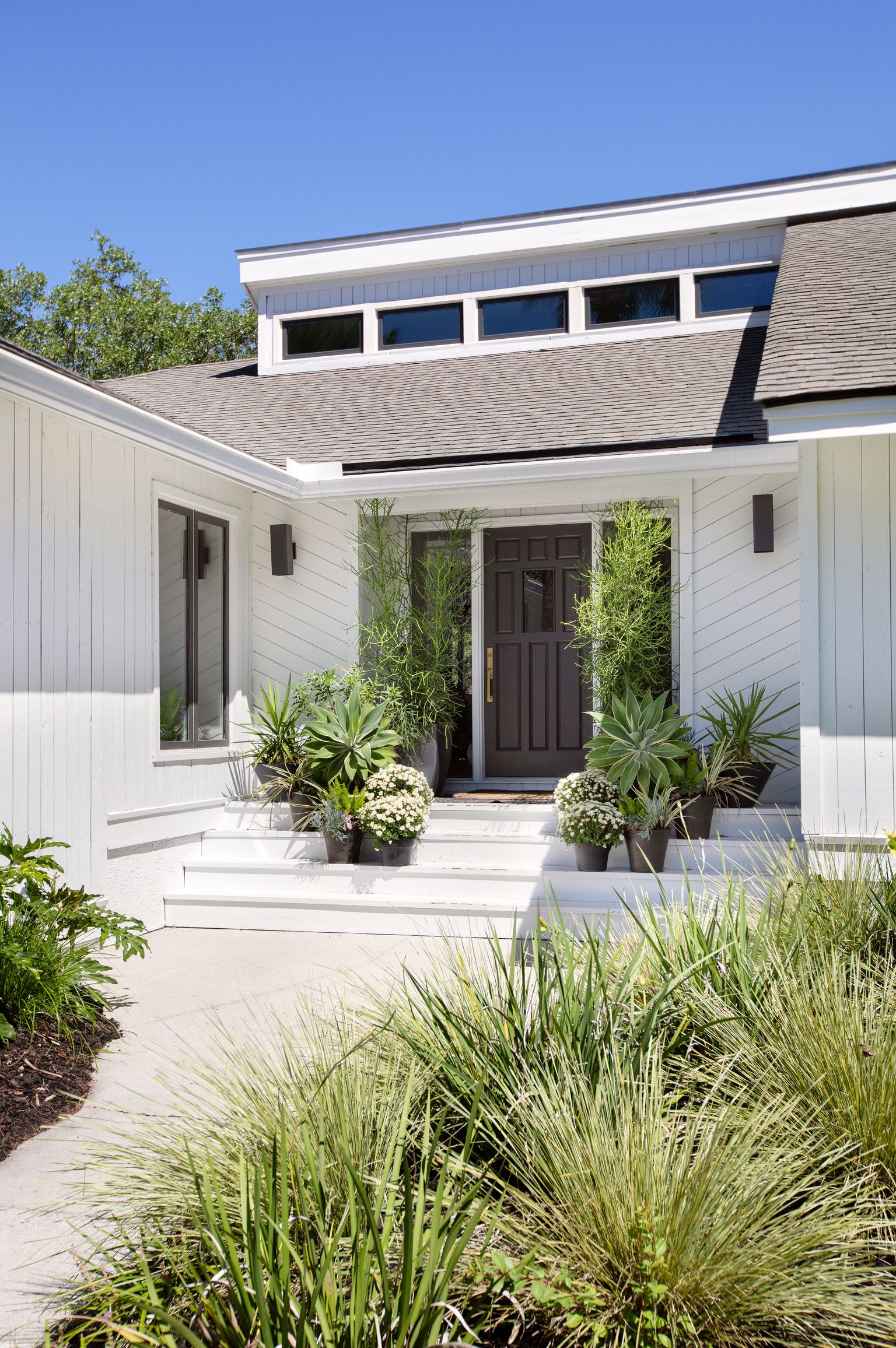 front yard landscaping projects, a simple home entry framed with potted plants and ornamental grasses  