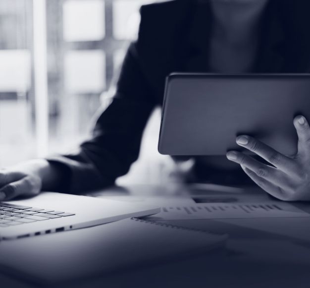 A person using both a laptop and a tablet