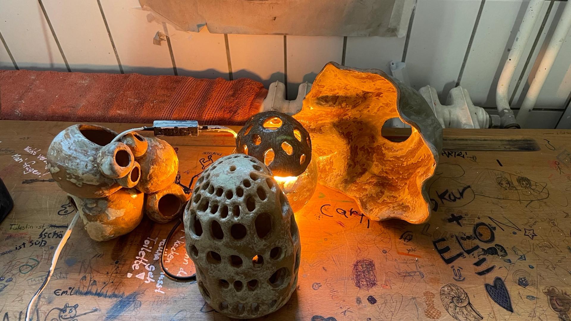 Collection of sculptural ceramic lamps illuminated