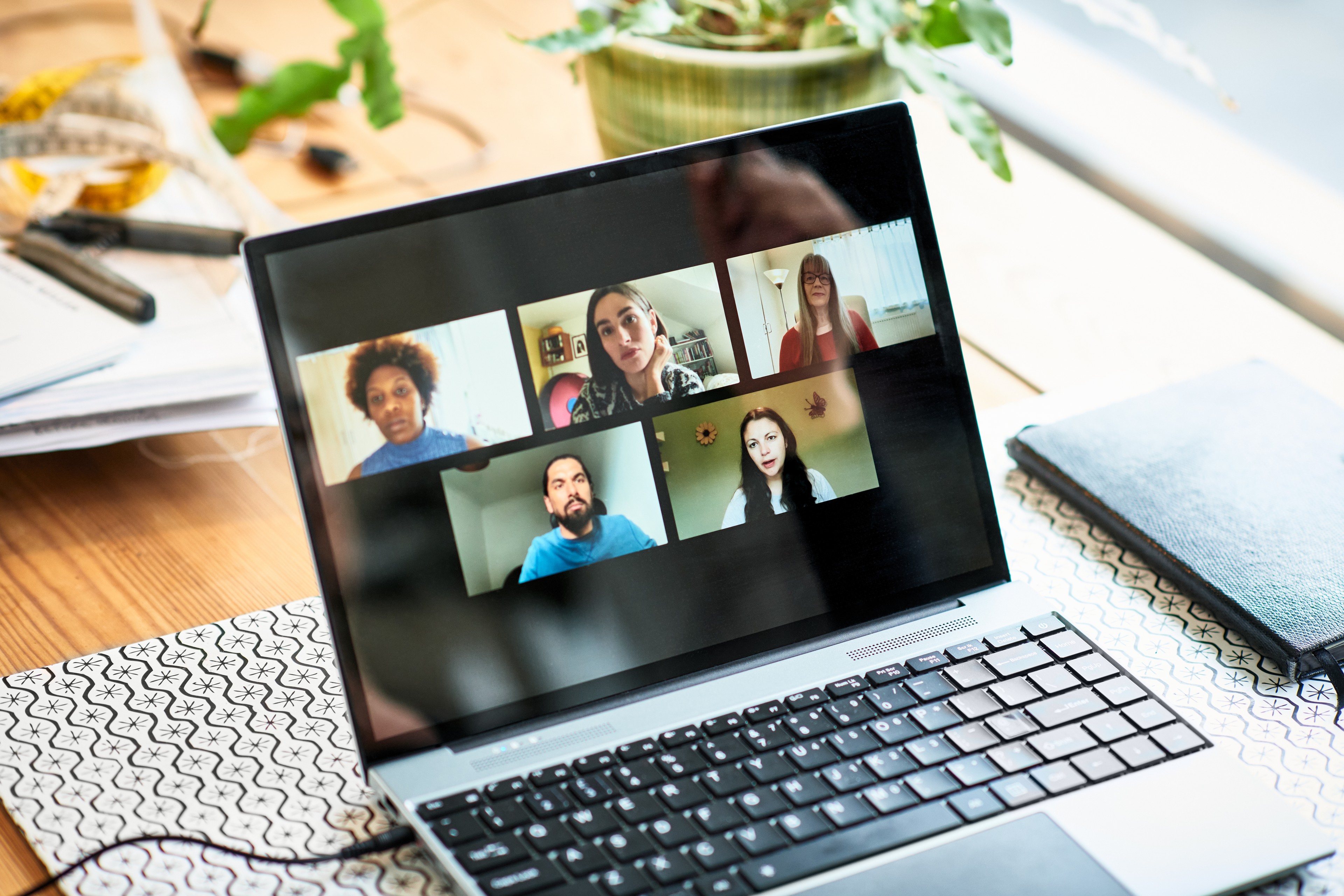 Five faces on laptop screen during video conference
