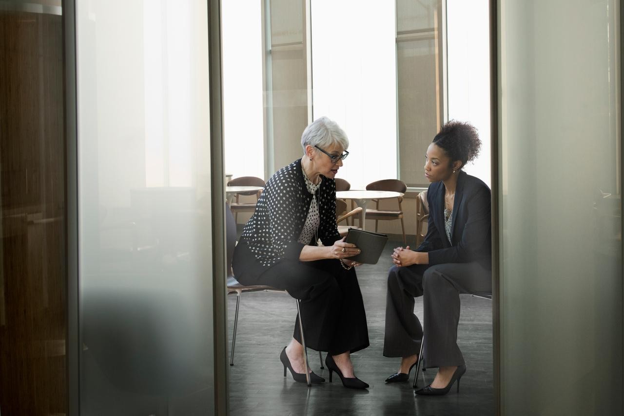 Women collaborating in a boardroom by sharing a tablet