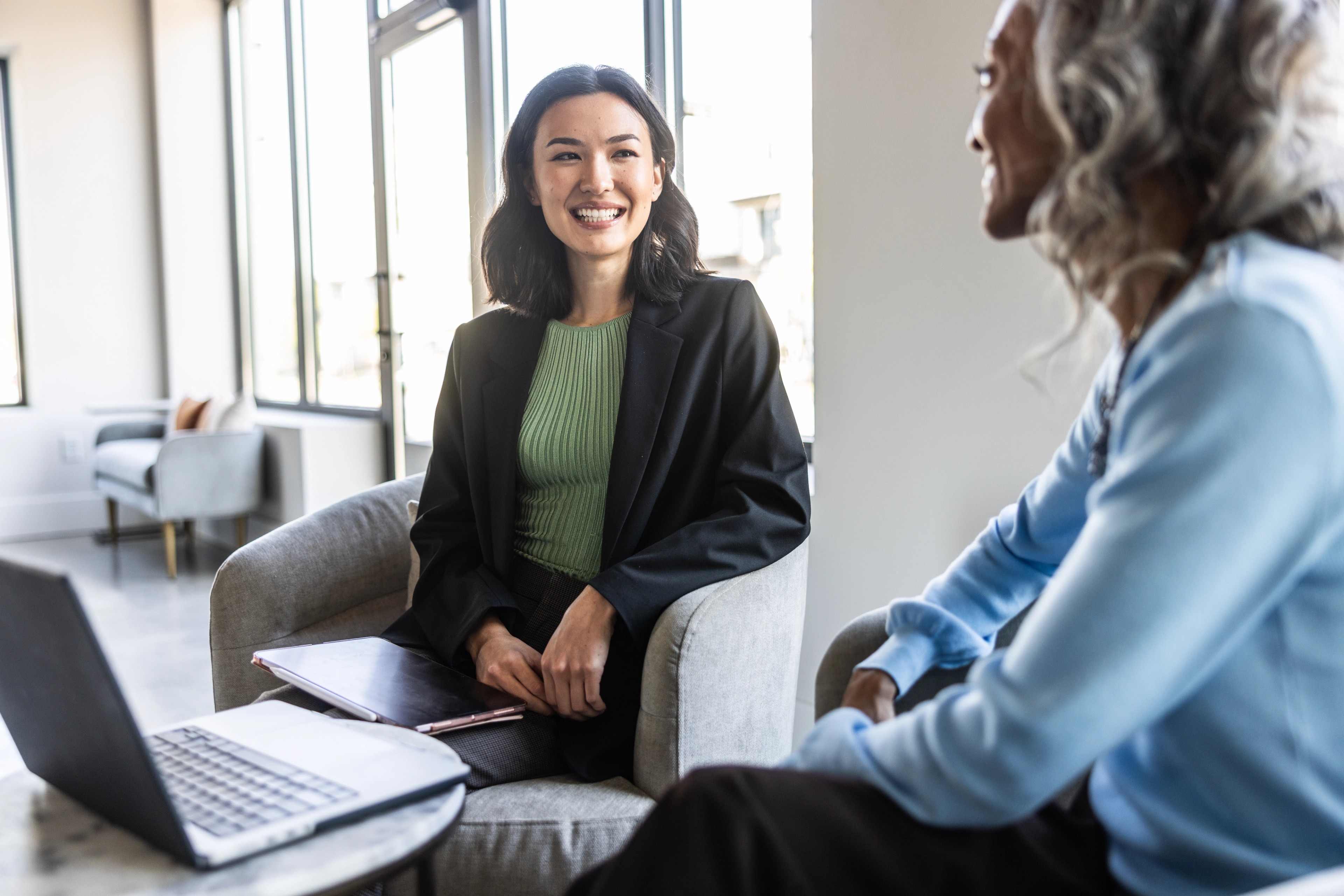 Businesswomen talking modern office lobby