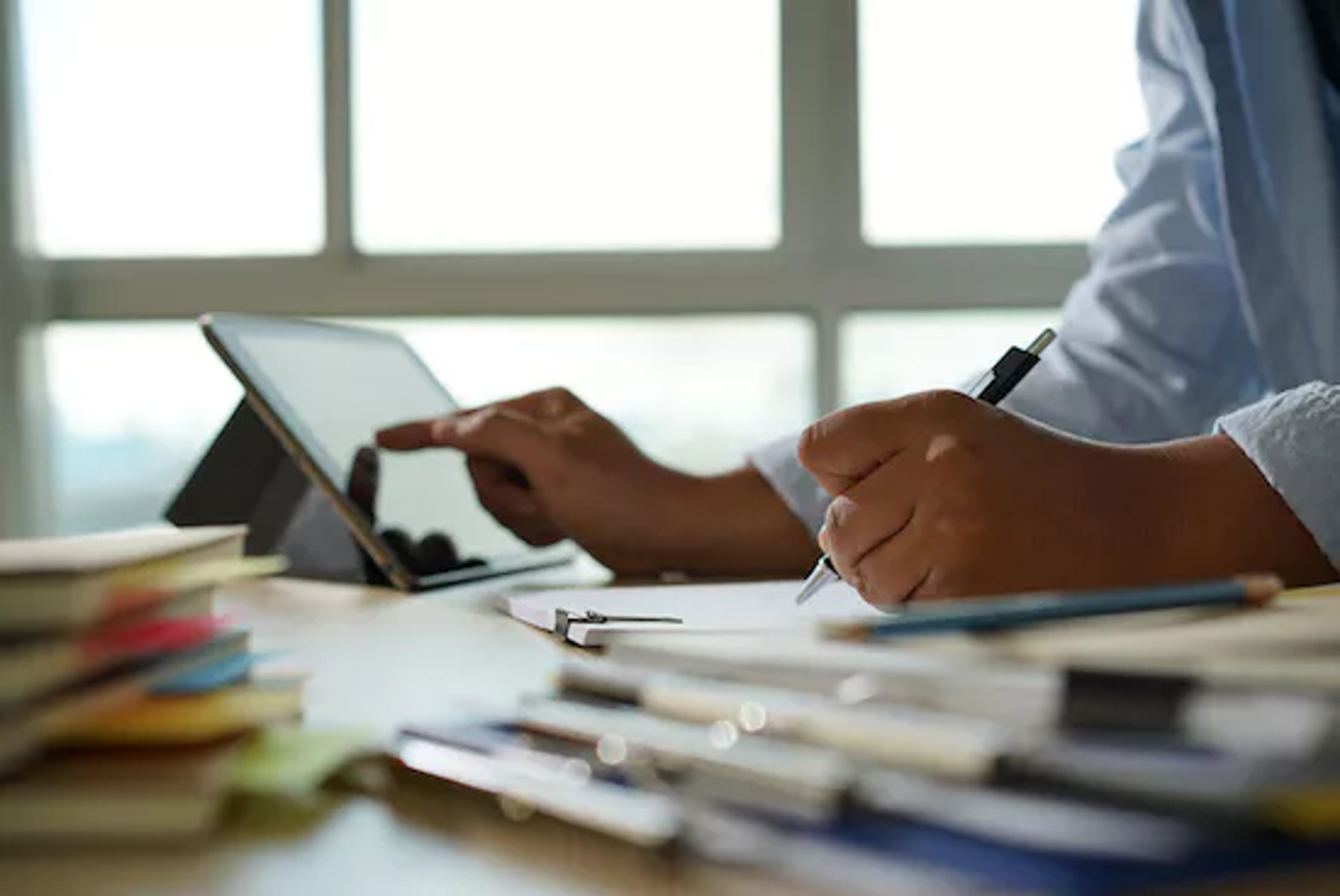 A professional with a tablet considering the advantages of a contract management system.