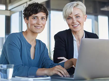 LGBTQ+ board members sitting at laptop, discussing the lavender ceiling