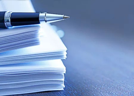 Image of a pen a stack of documents signifying the importance of keeping entity documents in a unified system.