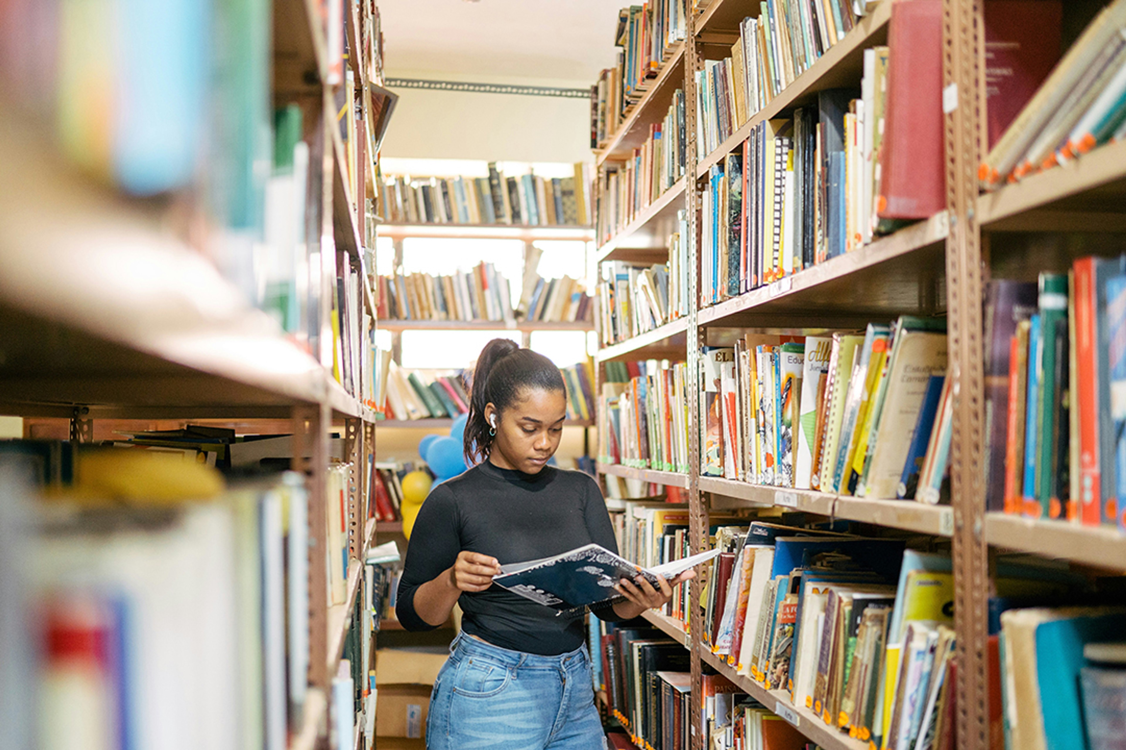 Image of high school student reading in library