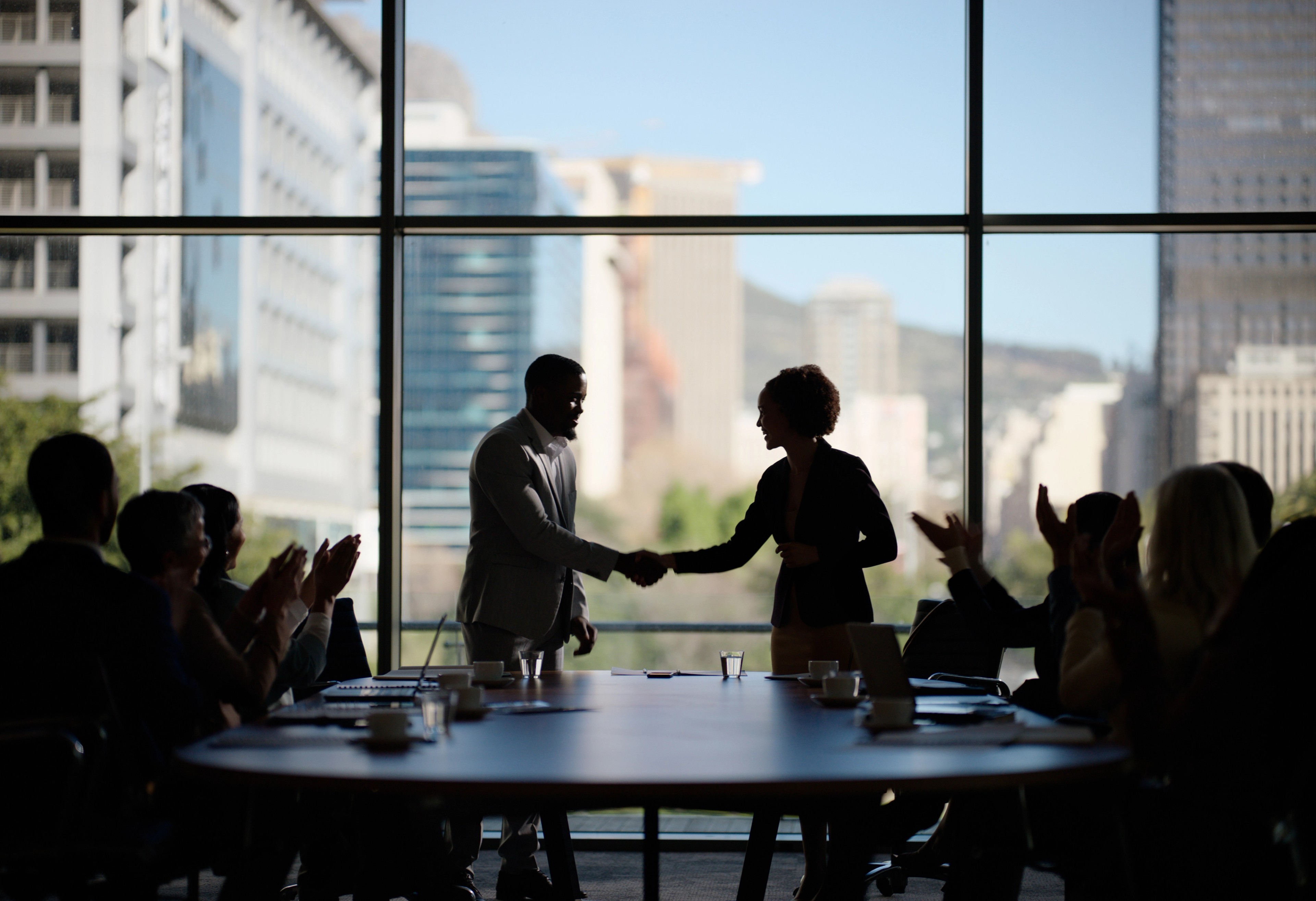 Business people, clapping and handshake for deal in boardroom