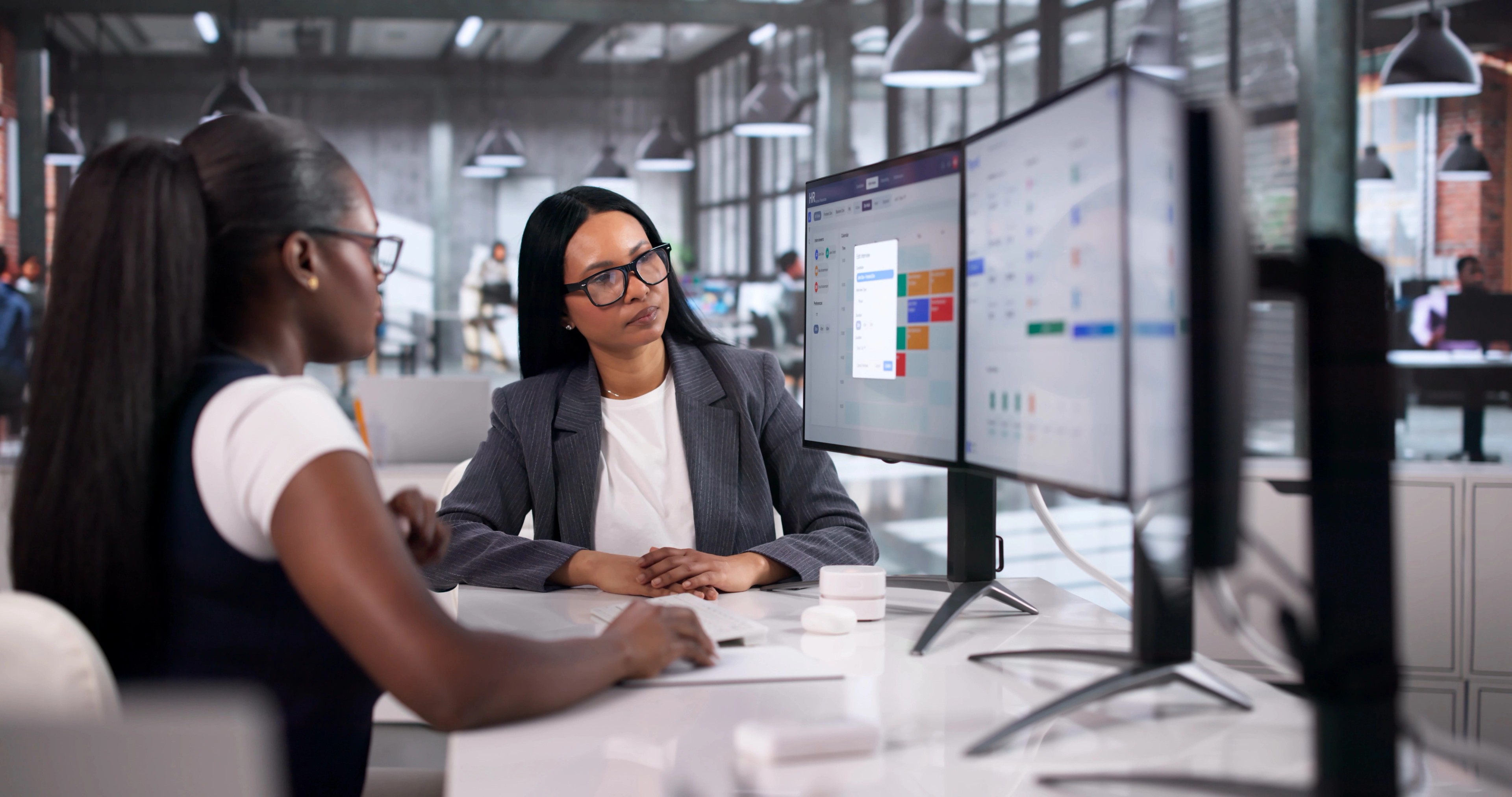 Human Resource Manager Explains Payroll Software To Two Women Colleagues