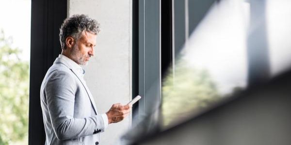 Business man reading Diligent's 2025 risk and opportunity outlook to stay ahead of AI regulations and other corporate governance trends