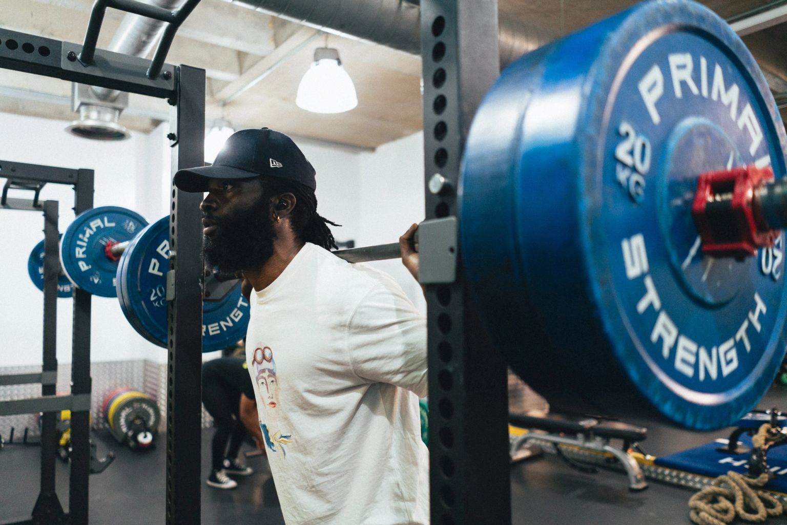A member unracking a loaded barbell in the squat rack at Fit This