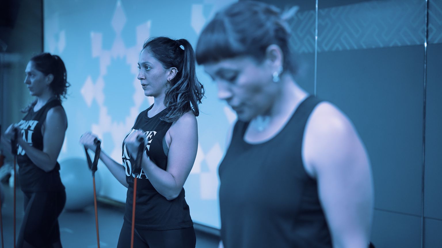 Members training with resistance bands in a class at Fit This