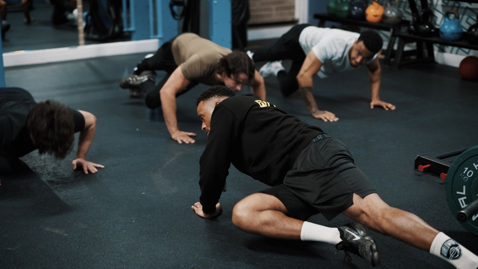 Members holding a press-up position together during a class