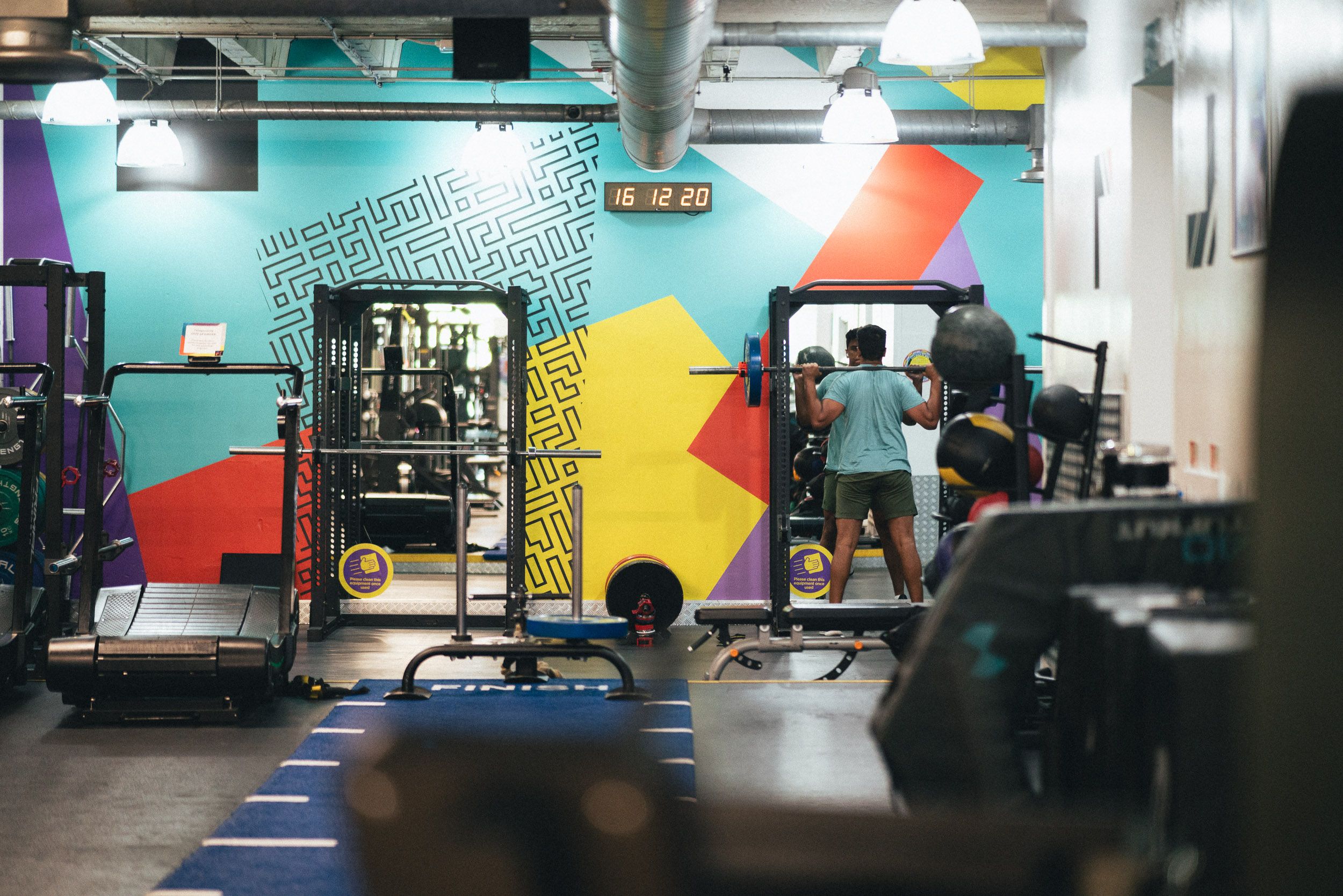 The Fit This gym floor, with squat racks in front of the colourful wall mural