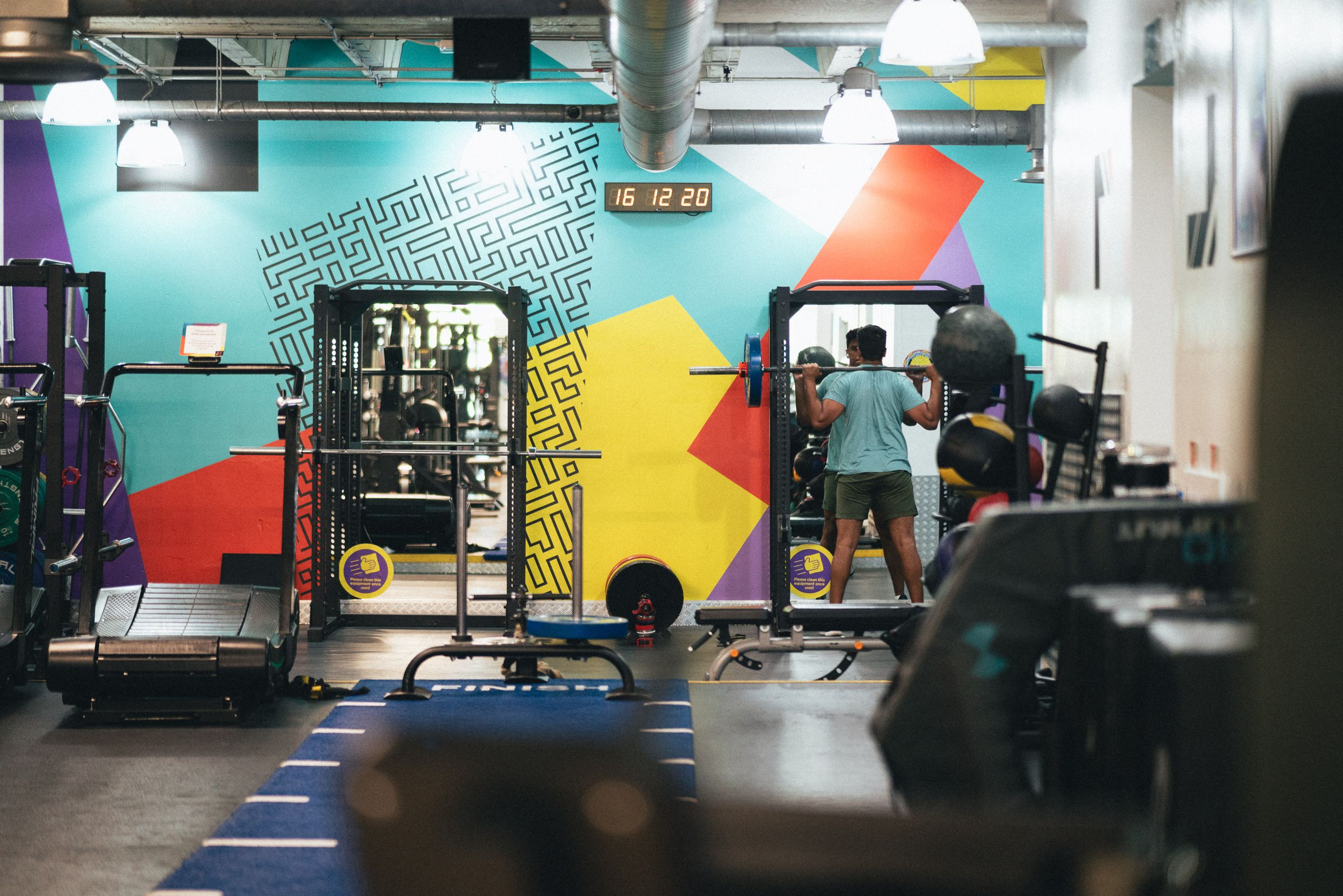 The Fit This gym floor, with squat racks in front of the colourful wall mural