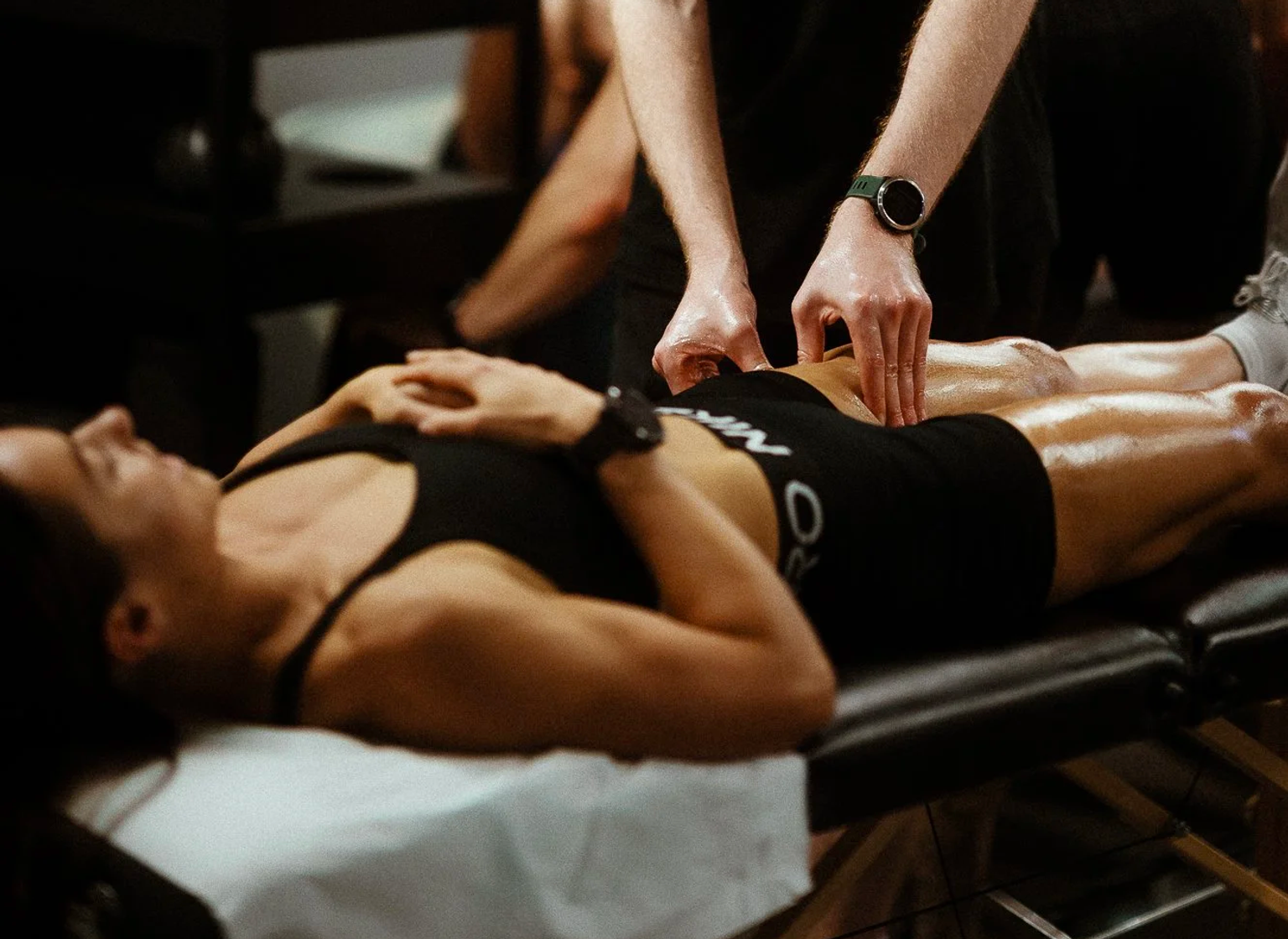 A physiotherapist treating a client on a couch at the in-house LDN Physio clinic