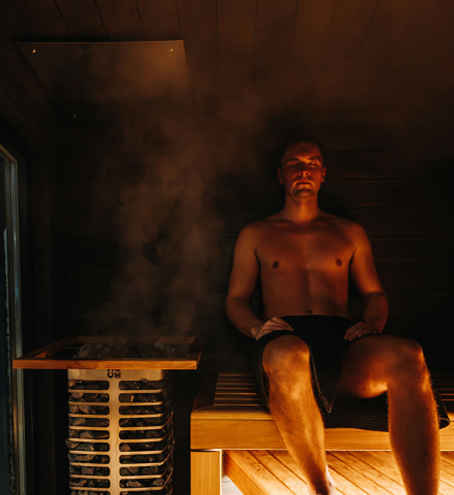 Man sitting on a bench in a steamy sauna