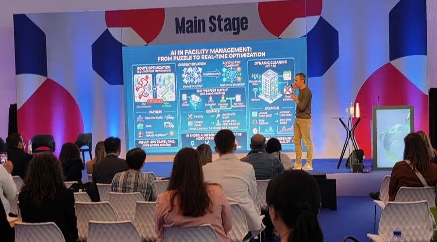 Spreker op die Interclean Main Stage met infografiek oor KI in fasiliteitsbestuur