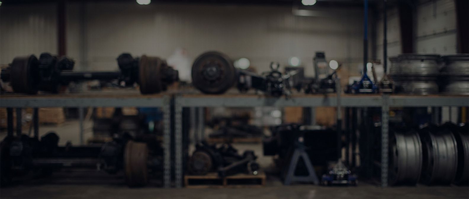 Trailer parts department with Dexter axle hubs, brake shoes, and wiring on a steel workbench