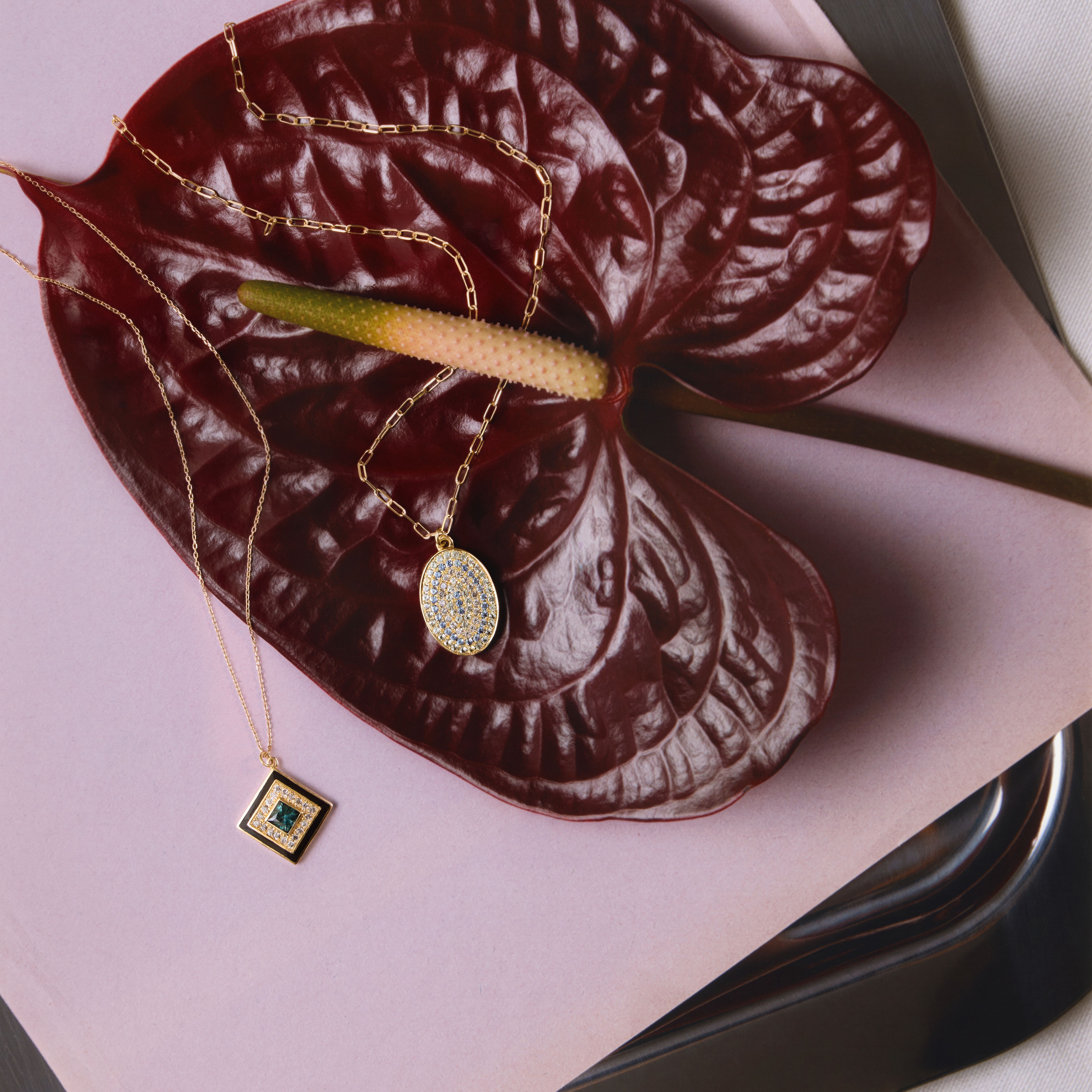 photo de deux colliers Sophie d'Agon sur une feuille de plante rouge | © Studio Cent-Huit 2025