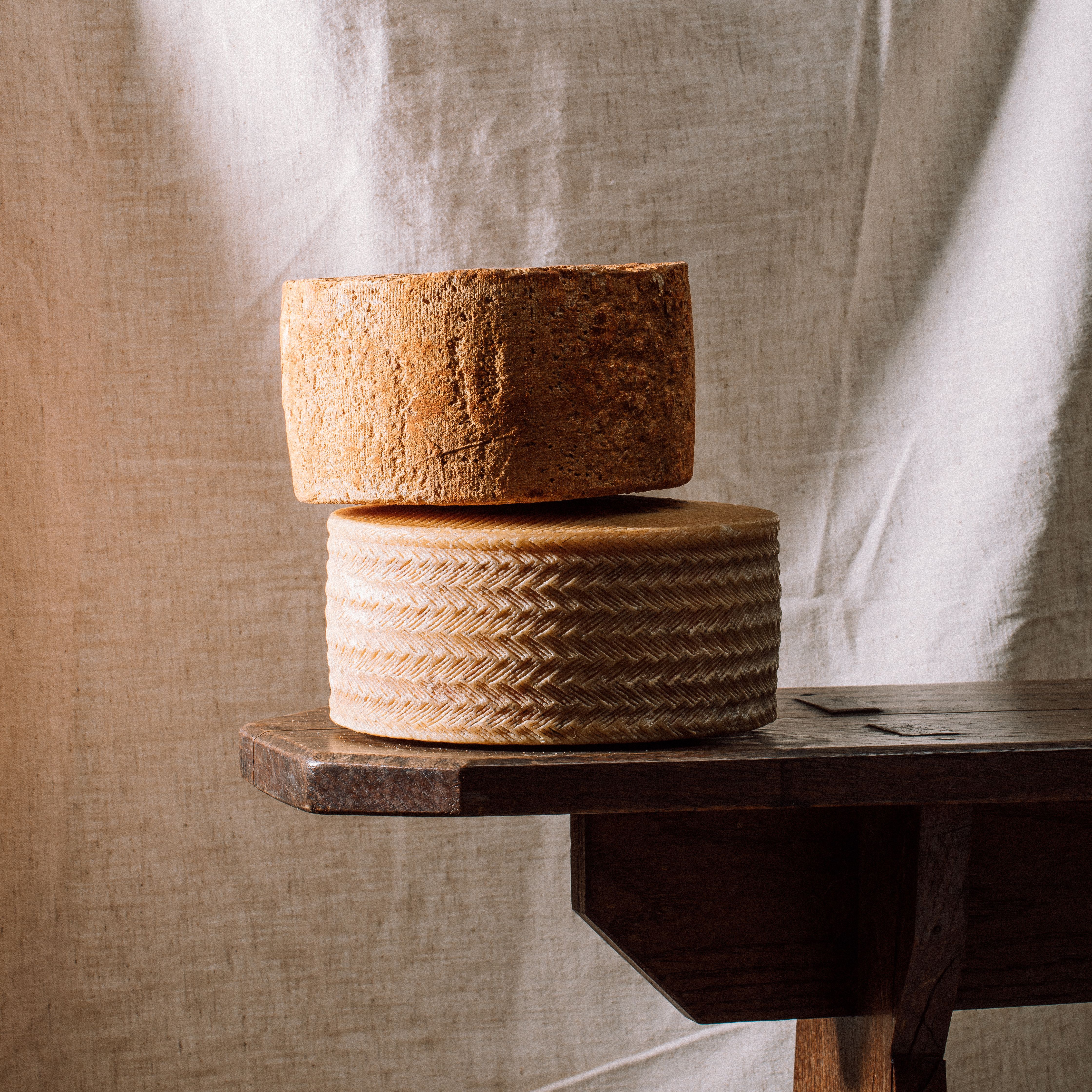 Photo meules de fromage sur banc en bois | © Studio Cent-Huit 2025
