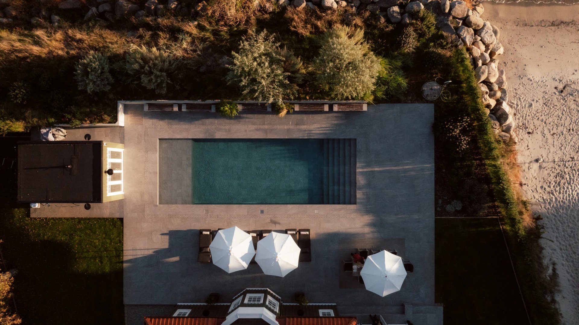 Overhead view of Villa Sand’s swimming pool and white parasols