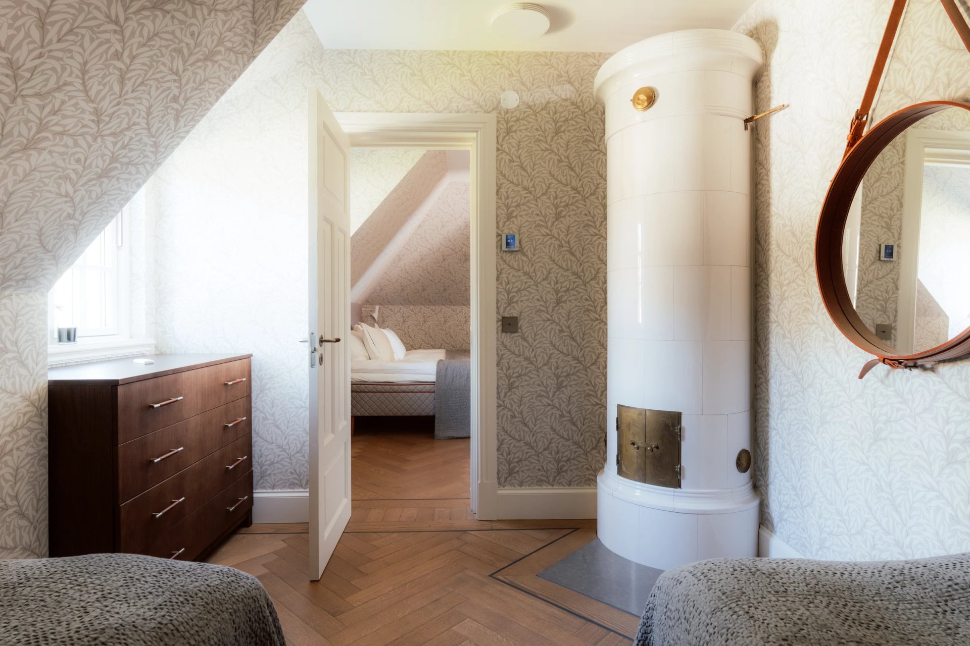 Traditional white tiled stove beside a Villa Sand bedroom